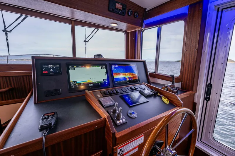 Slide: The Image of 2024 Nordic Tug 40 helm with modern navigation equipment and ocean view. - 10