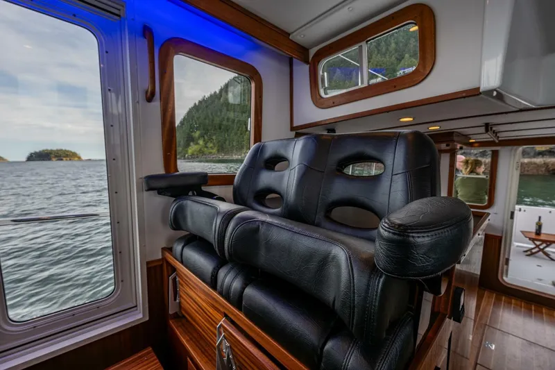 Slide: The Image of Luxurious interior of 2024 Nordic Tug 40 with leather seating and scenic water view. - 11