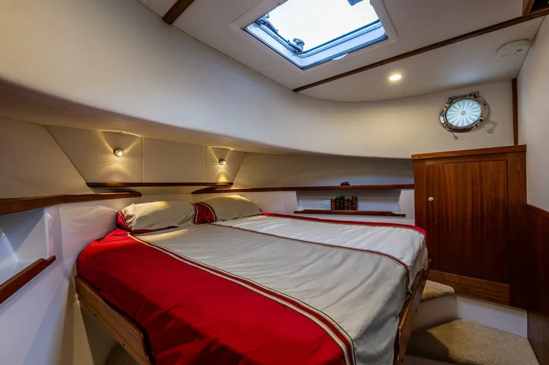 Slide: The Image of 2024 Nordic Tug 40 cabin with skylight, cozy bed, and wooden accents. - 16