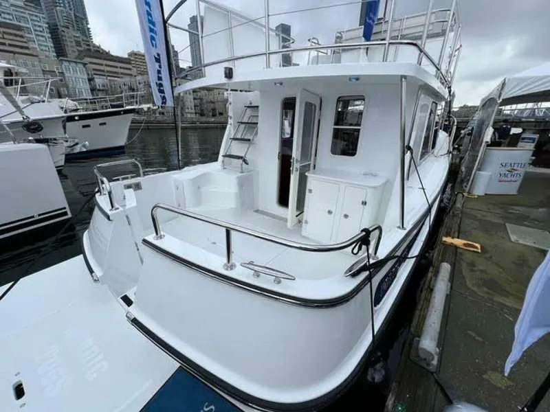 Slide: The Image of 2024 Nordic Tug 40 docked at marina, showcasing spacious deck and modern design. - 22