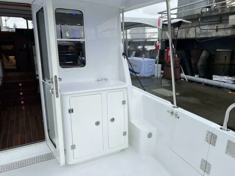 Slide: The Image of 2024 Nordic Tug 40 boat interior with white cabinetry and wooden flooring. - 25