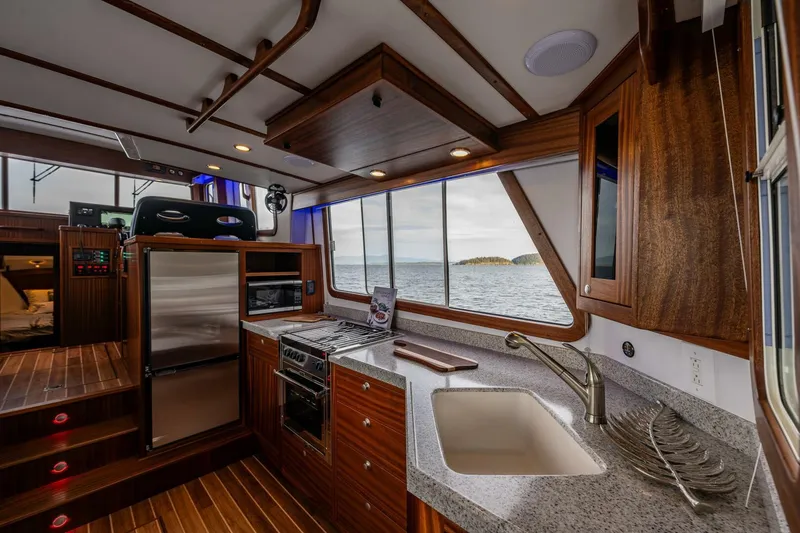 Slide: The Image of 2024 Nordic Tug 40 interior with modern kitchen and ocean view. - 7