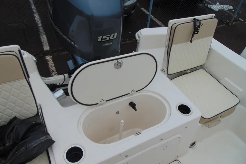 Slide: The Image of 2020 Carolina Skiff 21 LS boat interior with Yamaha 150 engine, seating, and storage compartment. - 8