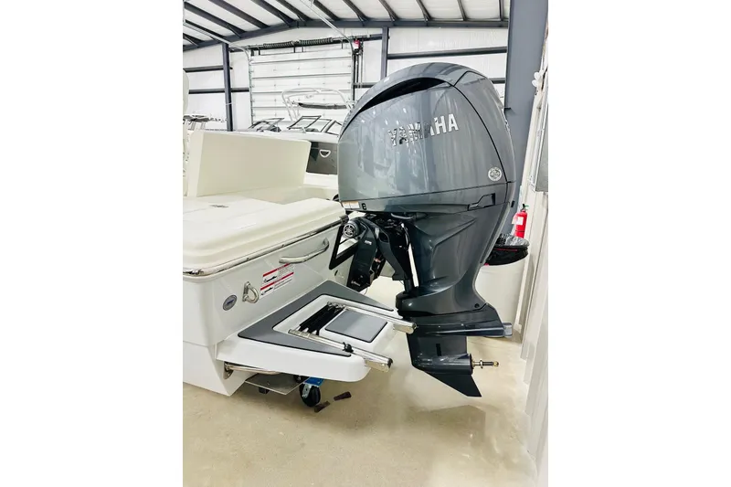 Slide: The Image of 2026 Pathfinder 2200 TRS boat with Yamaha outboard motor in a storage facility. - 16