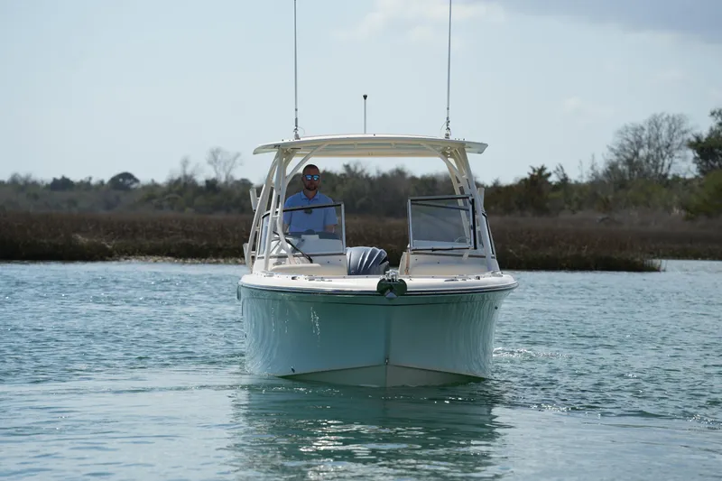Slide: The Image of 2021 Grady-White Freedom 235 boat cruising on calm water with scenic background. - 10