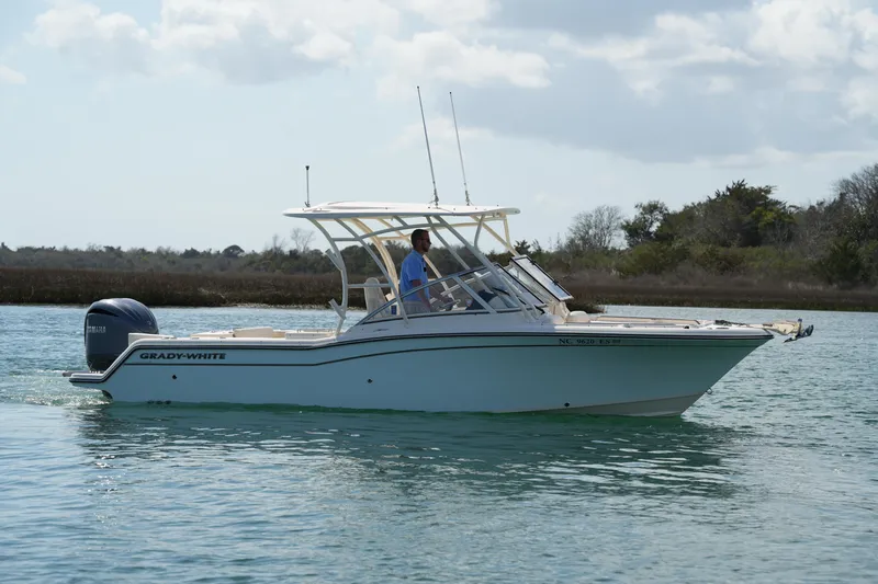 Slide: The Image of 2021 Grady-White Freedom 235 boat cruising on calm water under a cloudy sky. - 14