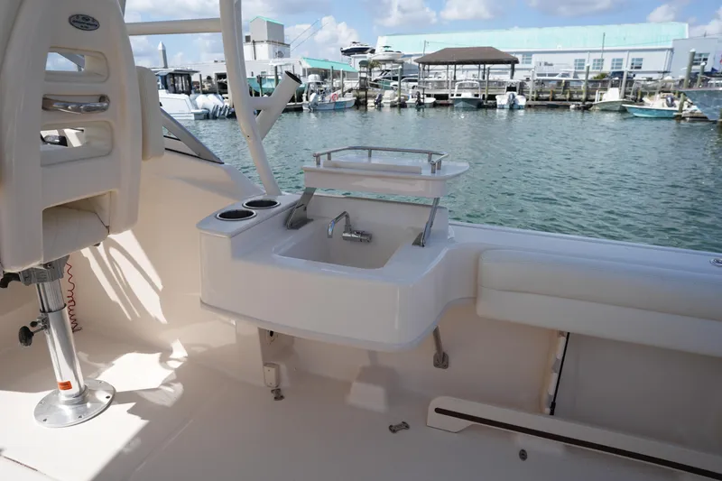 Slide: The Image of 2021 Grady-White Freedom 235 boat interior with sink and seating, docked at marina. - 24