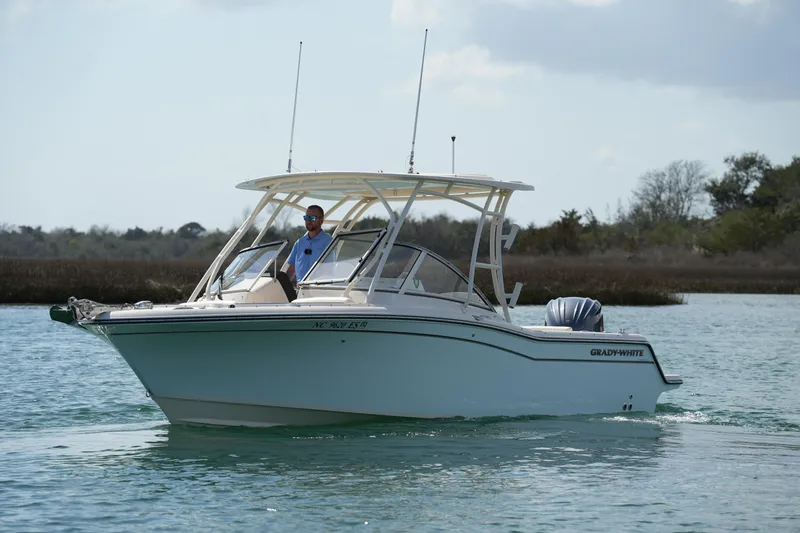 The Image of 2021 Grady-White Freedom 235 boat cruising on calm water with a person onboard. - 3