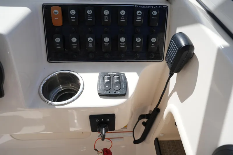 Slide: The Image of Control panel of 2021 Grady-White Freedom 235 boat with switches and microphone. - 34