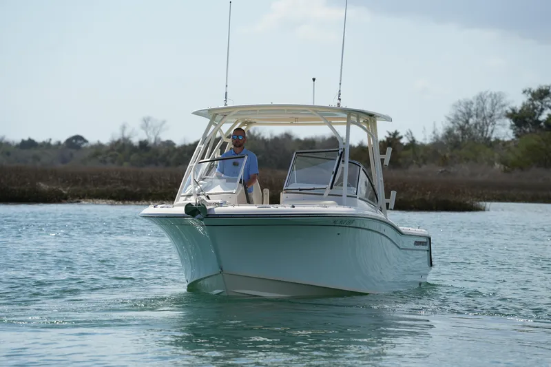 Slide: The Image of 2021 Grady-White Freedom 235 boat cruising on a calm waterway. - 9