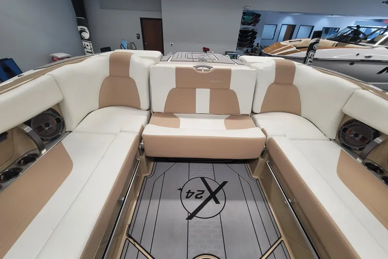 Slide: The Image of 2022 MasterCraft X24 boat interior with beige and white seating, modern design. - 12