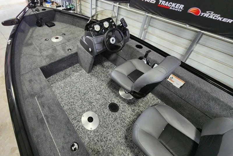 Slide: The Image of 2026 Tracker Super Guide V-16 SC boat interior with gray seating and control console. - 10