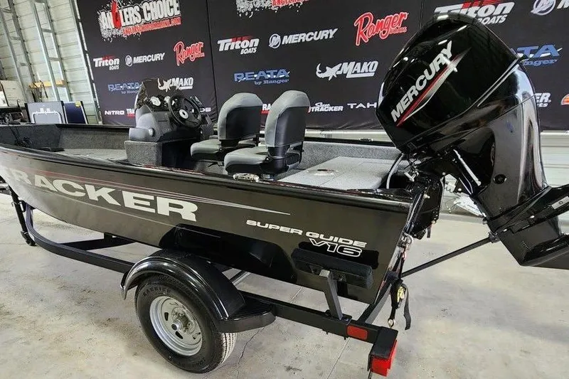 Slide: The Image of 2026 Tracker Super Guide V-16 SC boat with Mercury engine in showroom. - 3