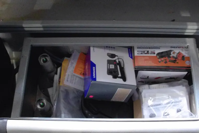 Slide: The Image of Storage compartment in a 2024 Smoker Craft Phantom 20 X2, filled with boating accessories and equipment. - 15