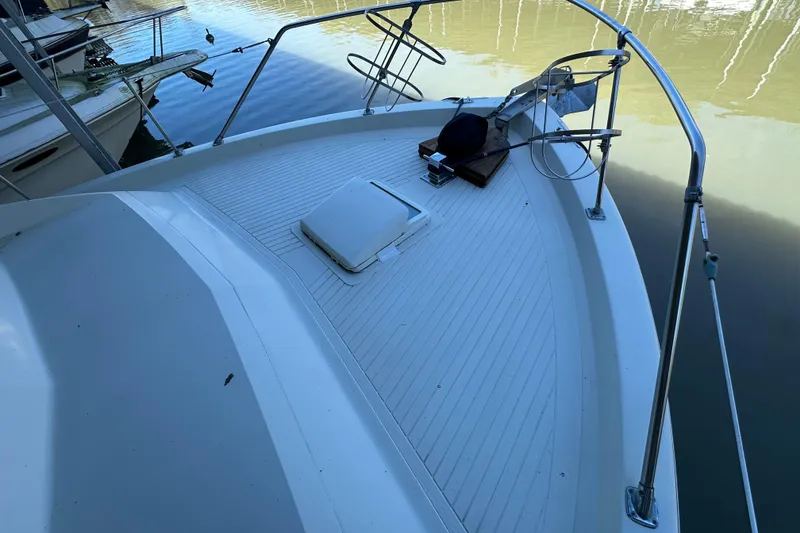 Slide: The Image of 1968 Chris-Craft 35 Commander boat deck with railing and hatch, docked on calm water. - 17