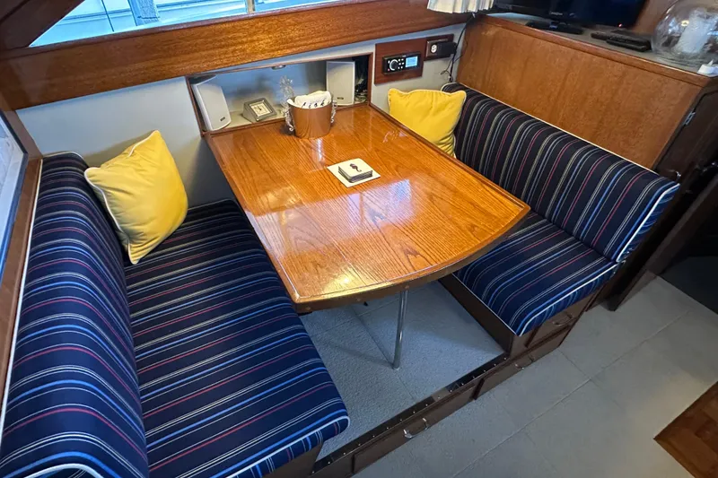 Slide: The Image of 1968 Chris-Craft 35 Commander interior with striped seating and wooden table. - 2