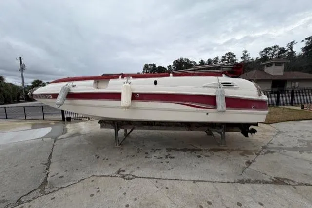 Slide: The Image of Chaparral 232 Sunesta 2000 boat on trailer, red and white design, parked outdoors. - 13