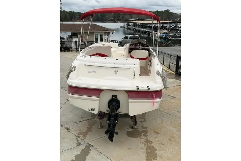 Slide: The Image of 2000 Chaparral 232 Sunesta boat with red canopy docked at marina. - 4