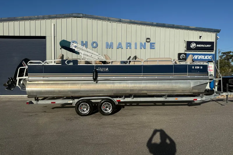 The Image of 2021 Avalon 2480 GF pontoon boat on trailer outside marine shop. - 1
