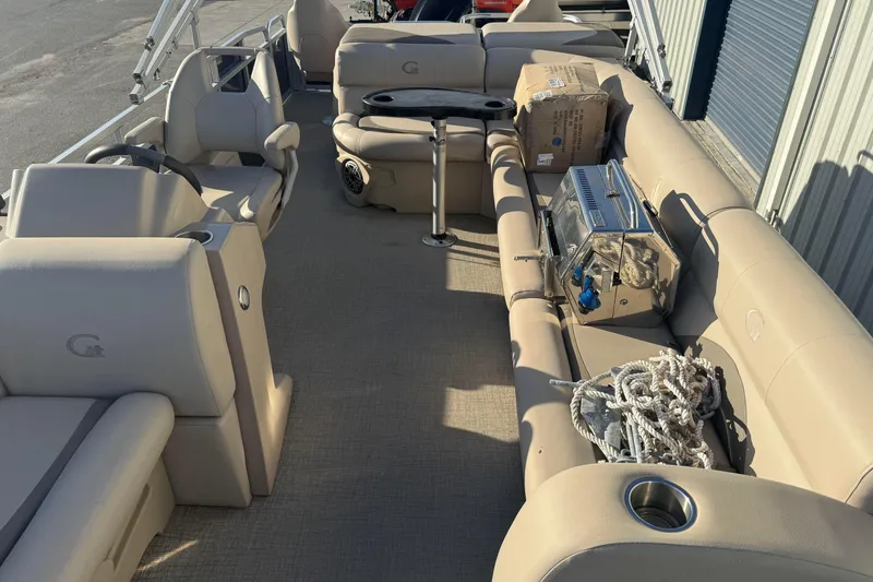 Slide: The Image of 2021 Avalon 2480 GF pontoon boat interior with beige seating and accessories. - 14