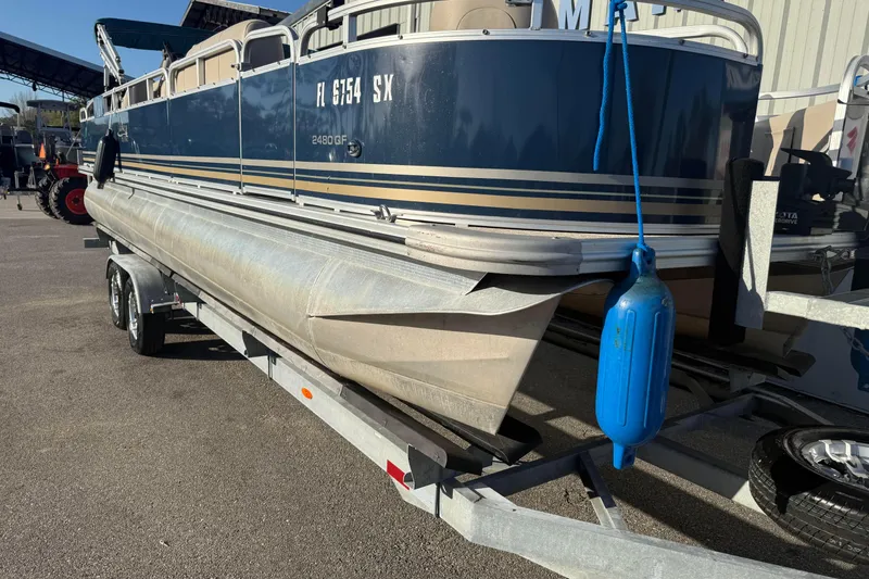Slide: The Image of 2021 Avalon 2480 GF pontoon boat on trailer, blue and beige design. - 16
