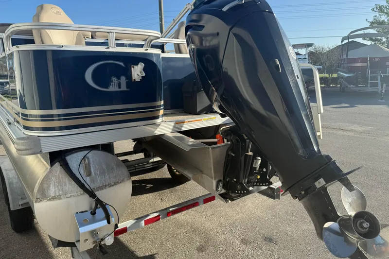 Slide: The Image of 2021 Avalon 2480 GF pontoon boat with powerful outboard motor, parked on trailer. - 4