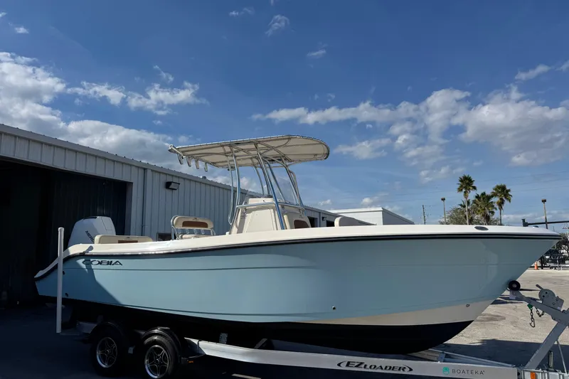 Slide: The Image of 2024 Cobia 237 Center Console boat on trailer under blue sky. - 3