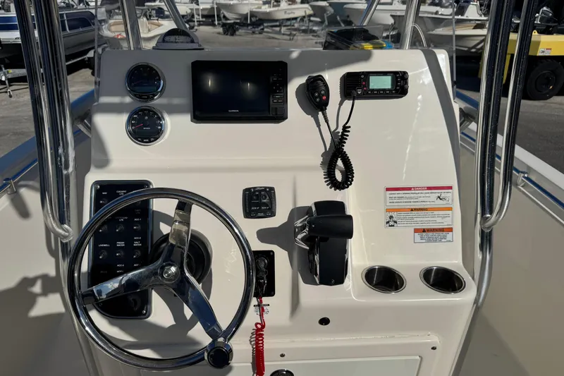 Slide: The Image of 2024 Cobia 237 Center Console boat dashboard with steering wheel and navigation controls. - 6