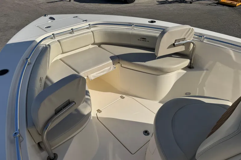 Slide: The Image of 2024 Cobia 237 Center Console boat interior with cushioned seating and stainless steel railings. - 8