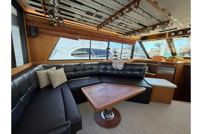 Slide: The Image of Luxurious interior of 1993 Riviera 47 Open Flybridge yacht with leather seating and fishing rods. - 10