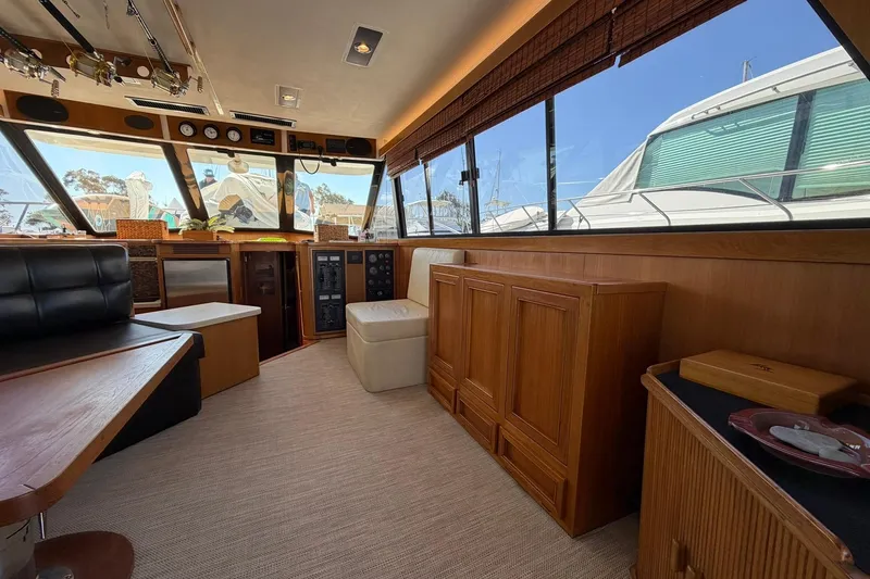 Slide: The Image of Interior of 1993 Riviera 47 Open Flybridge yacht with wood paneling and large windows. - 11