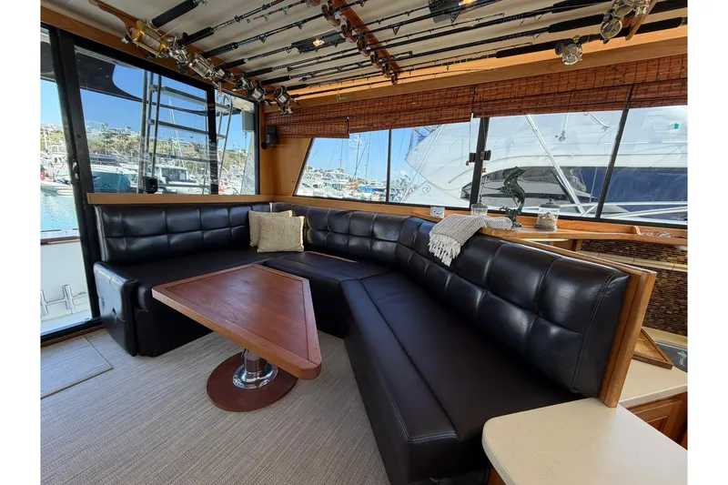 Slide: The Image of Interior of 1993 Riviera 47 Open Flybridge yacht with TV and marina view. - 12