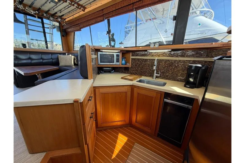 Slide: The Image of Luxurious interior of 1993 Riviera 47 Open Flybridge with leather seating and fishing rods. - 13