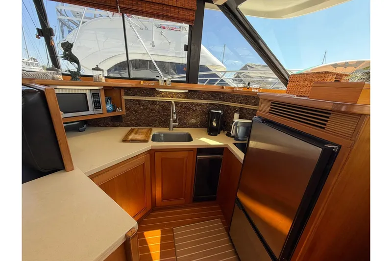 Slide: The Image of Luxurious 1993 Riviera 47 Open Flybridge yacht interior with modern kitchen and seating area. - 14