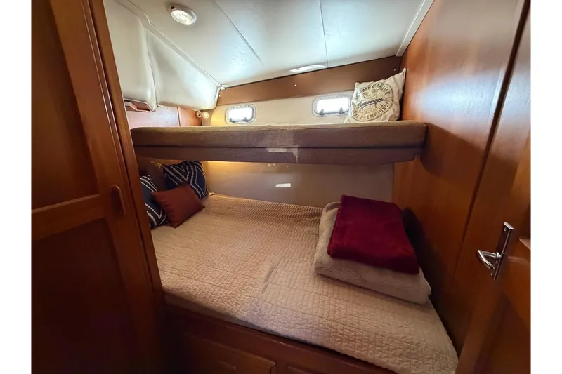 Slide: The Image of Cozy bedroom in 1993 Riviera 47 Open Flybridge yacht with wooden accents and nautical decor. - 18