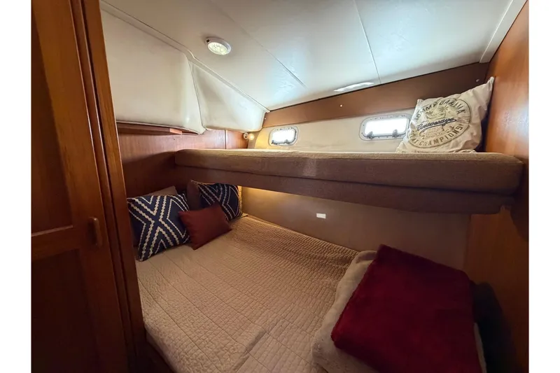 Slide: The Image of Cozy cabin interior of 1993 Riviera 47 Open Flybridge with bunk beds and warm lighting. - 19