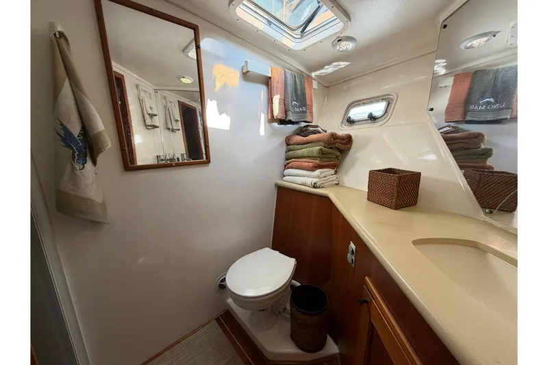 Slide: The Image of Bathroom interior of 1993 Riviera 47 Open Flybridge yacht, featuring a skylight and wooden cabinetry. - 24
