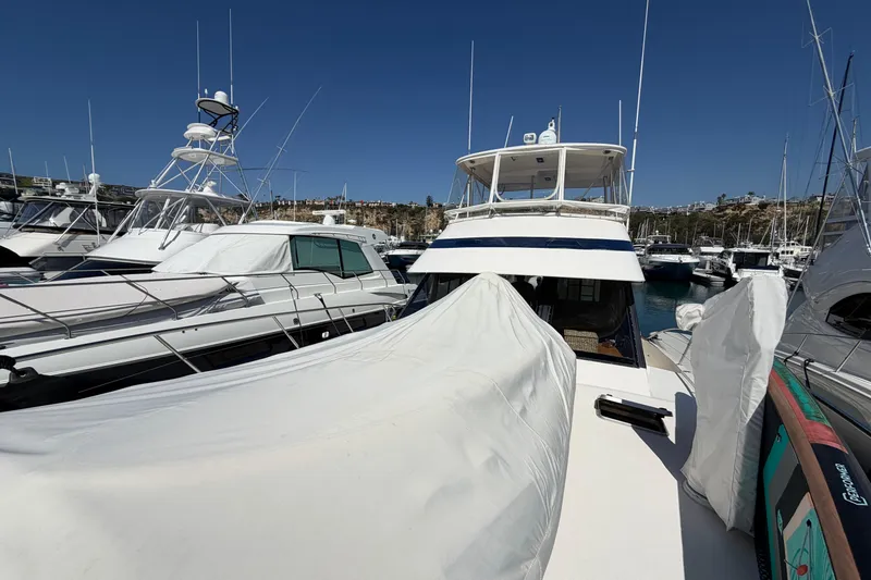 Slide: The Image of 1993 Riviera 47 Open Flybridge yacht with sleek deck and ladder in marina setting. - 27