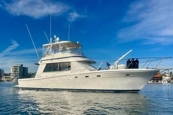 Slide: The Image of 1993 Riviera 47 Open Flybridge yacht on calm water under clear blue sky. - 4