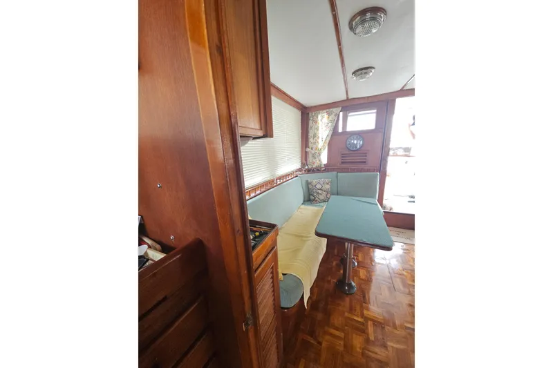 Slide: The Image of Interior of 1977 Universal Marine Europa boat with wooden furnishings and cozy seating area. - 29