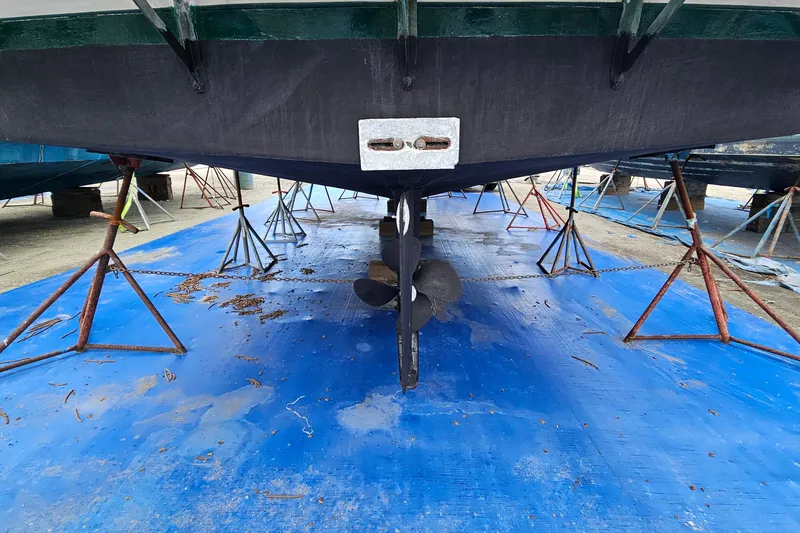 Slide: The Image of 1977 Universal Marine Europa boat hull on stands, blue tarp underneath. - 3