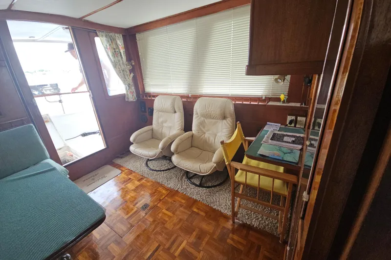 Slide: The Image of Interior of a 1977 Universal Marine Europa boat with cozy seating and wooden decor. - 30