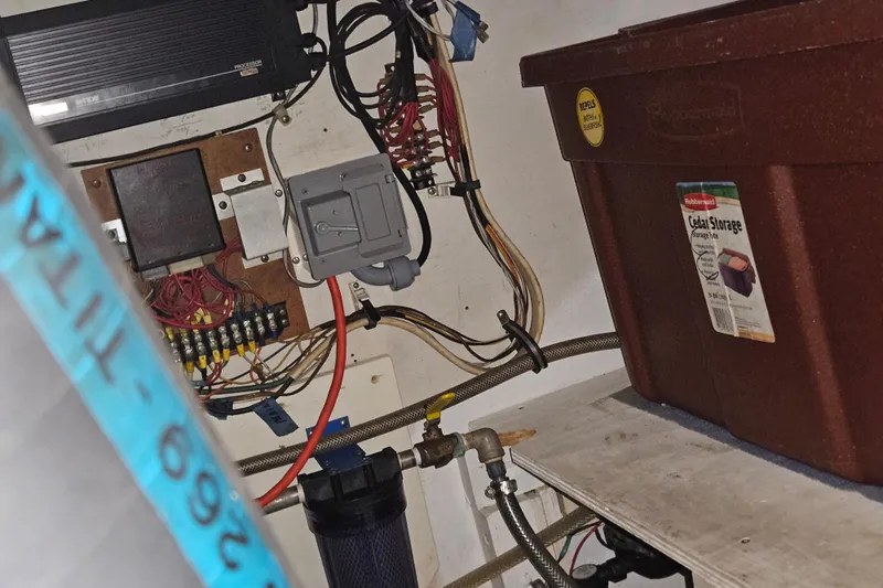 Slide: The Image of A boat engine room with wiring and a storage container. - 45