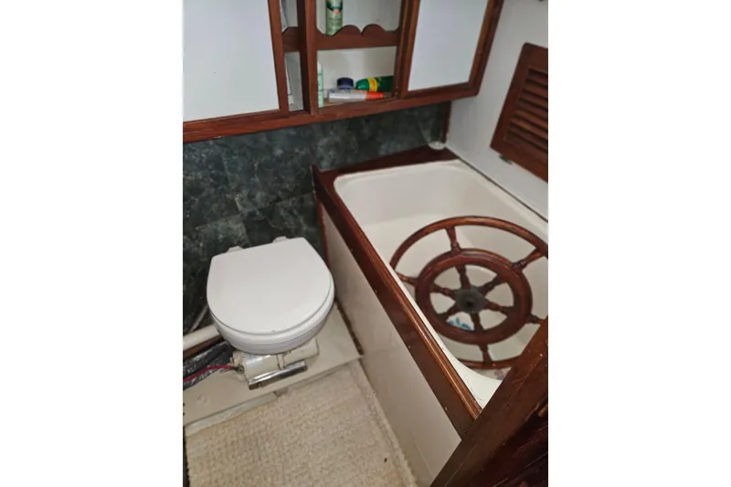 Slide: The Image of Bathroom interior of 1977 Universal Marine Europa boat with wooden accents and nautical decor. - 46