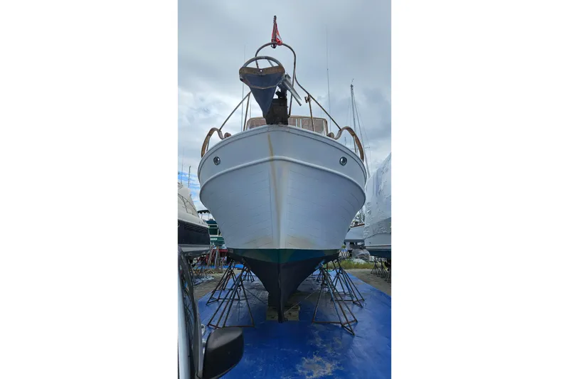 Slide: The Image of 1977 Universal Marine Europa boat on stands, viewed from the front, under cloudy skies. - 6
