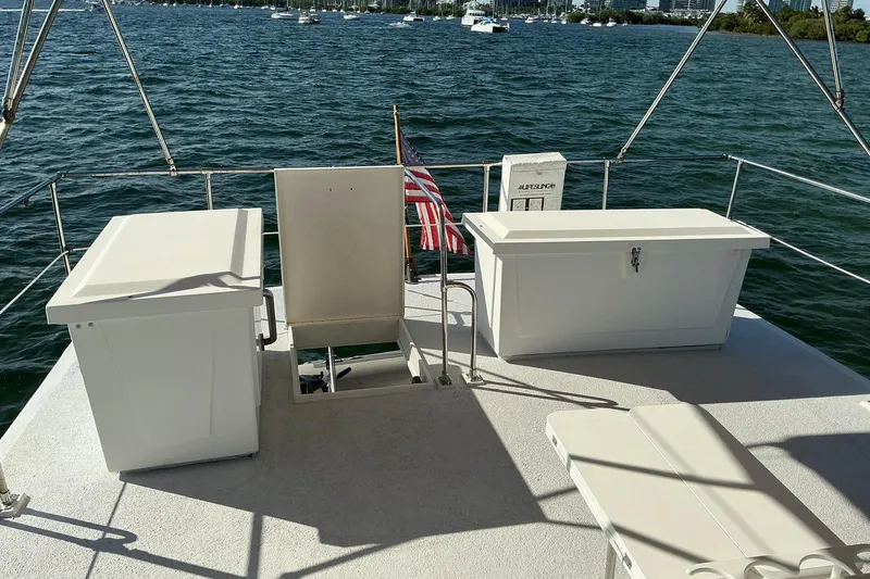 Slide: The Image of 1977 Universal Marine Europa boat deck with storage, overlooking a scenic water view. - 9