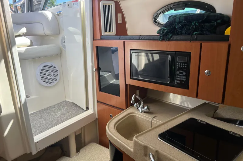 Slide: The Image of 2006 Wellcraft 290 Coastal interior with kitchenette, microwave, and seating area. - 11