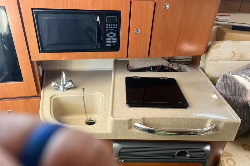 Slide: The Image of 2006 Wellcraft 290 Coastal boat interior with kitchenette, sink, and microwave. - 12
