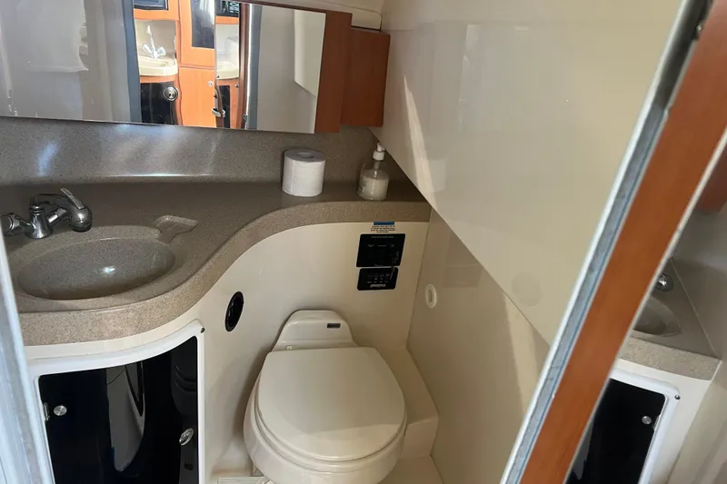 Slide: The Image of 2006 Wellcraft 290 Coastal bathroom with sink, toilet, and storage cabinets. - 13