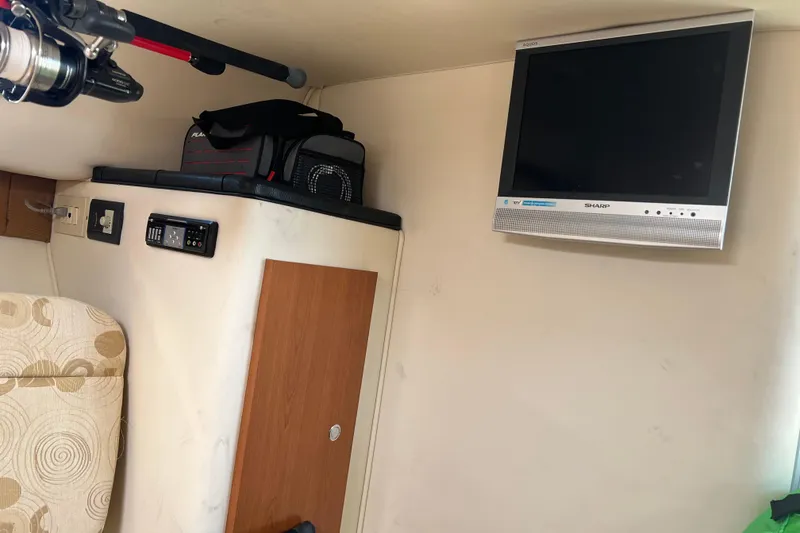 Slide: The Image of Interior of 2006 Wellcraft 290 Coastal with TV, fishing rod, and storage. - 18